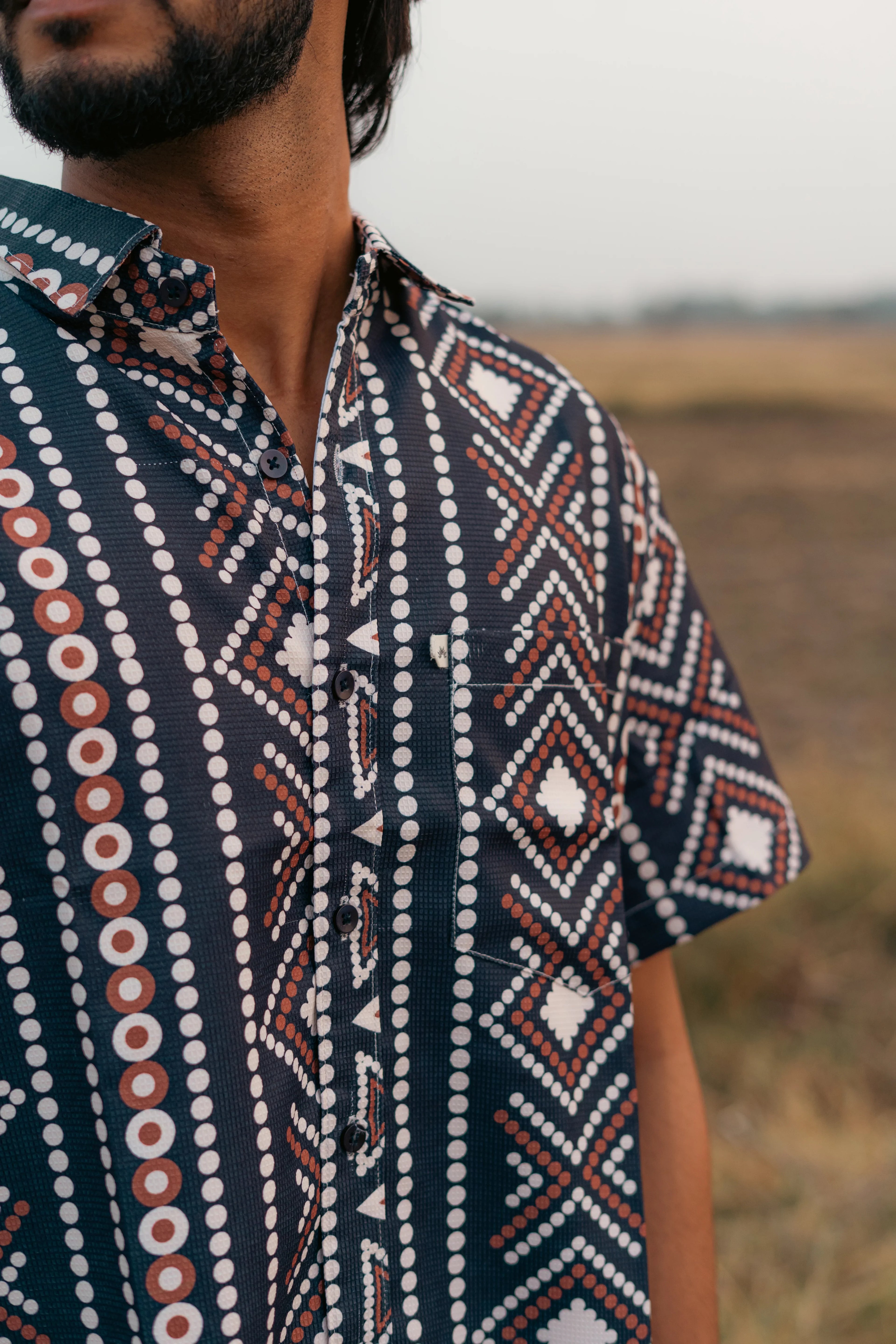 Men’s short sleeve shirt with geometric dot and diamond pattern outdoors